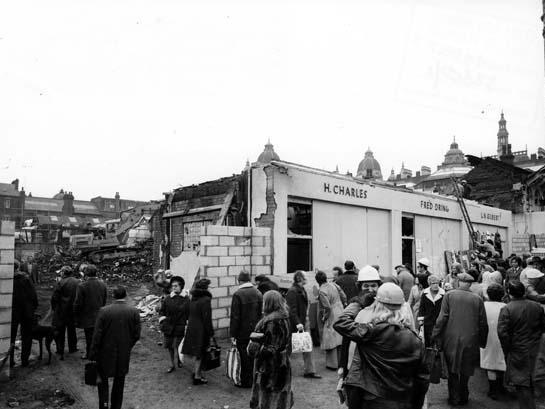 The picture shows Lower Butcher's Row, with the fire damaged shops of H. Charles, Fred Dring and L.N. Gilbert on the right.