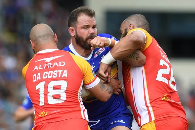 Adam Cuthbertson is tackled by Catalans Dragons' Alrix Da Costa and Sam Kasiano.