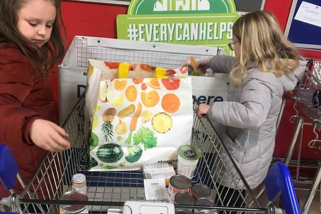 Ella and Ruby Forrester used their money they got from Elf on the Shelf this Christmas to buy cans of food for their local food bank