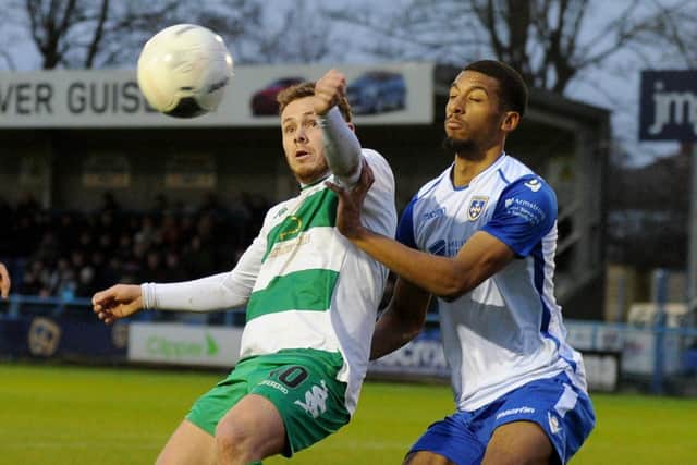 Nathan Cartman of Farsley is closely marked by Reiss McNally of Guisley.