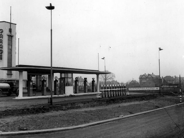 Alwoodley Motors Ltd garage on Harrogate Road adjacent to Sandmoor Drive. Petrol pumps and a tanker are on the forecourt. To the right is the entrance to Moortown Golf Club.