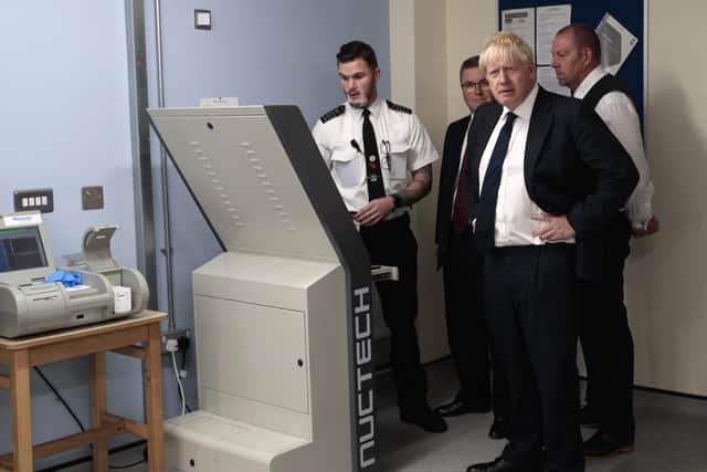 Prime Minister Boris Johnson, Justice Secretary Robert Buckland and HMP Leeds governor Steve Robson are shown a torso and body scanner by a member of prison staff during a visit to Leeds prison last August. Picture: Jon Super - WPA Pool/Getty Images