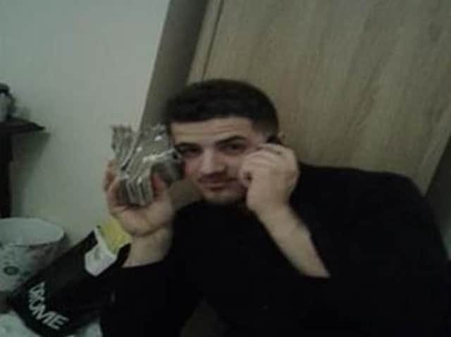 Michael Bendo posing with wads of cash for a photo taken on Hassan Jalilian's mobile phone.