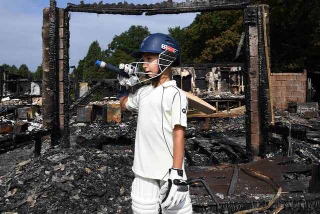 Junior player Sevan Chotai in front of the old pavilion - destroyed by an arson attack