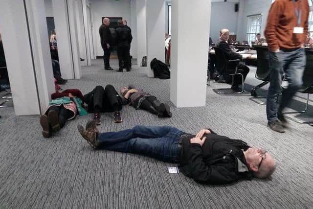 Protesters stage a 'die-in' at the Leeds Council meeting