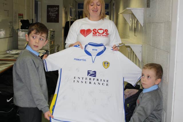 Carmen Greene and her sons Aiden and Keiran, with a signed Leeds United shirt for Wear Red Day.