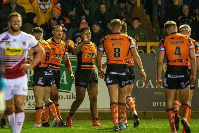 Derrell Olpherts, third Tigers player from left, celebrates his try against Wigan. Picture by Bruce Rollinson.