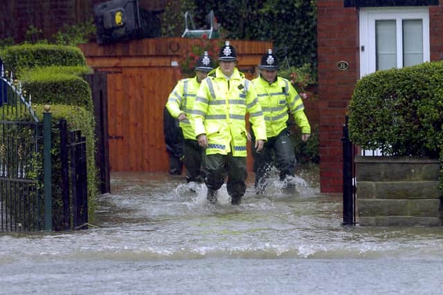 JUNE 2007: Police officers check homes in Halton after Wykebeck Valley Beck burst its banks. PIC: James Hardisty
