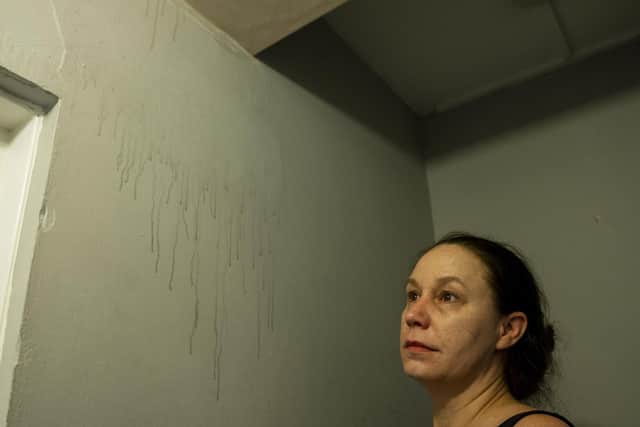 Ms Wardell shows where water is running down the walls of her flat.