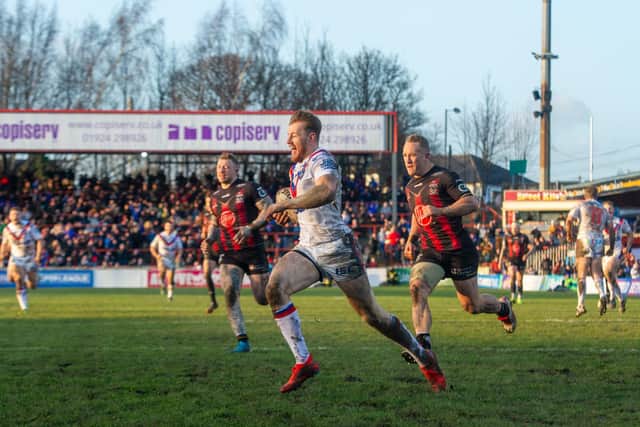 Tom Johnstone scores for Wakefield in the win over Warrington. Picture by Tony Johnson.