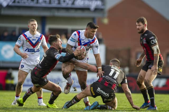 Warrington's Gareth Widdop and Ben Currie tackle Wakefield Trinity's Adam Tangata, as Daryl Clark, right, looks on. Picture by Tony Johnson.