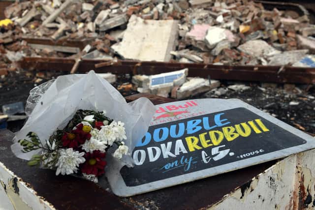 Flowers left among the rubble of The Gate pub at Seacroft.