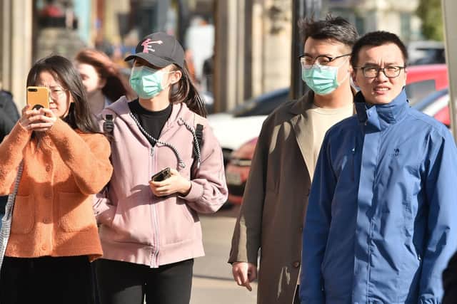 People in Wuhan, China, wearing face masks as 12 new cases of coronavirus are confirmed in the UK