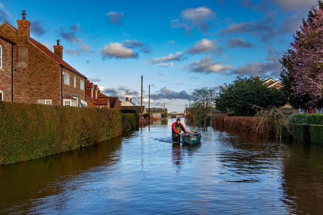 A man pushes a boat in East Cowick, East Yorkshire, as floodwater continues to affect many properties in the village. Picture: James Hardisty