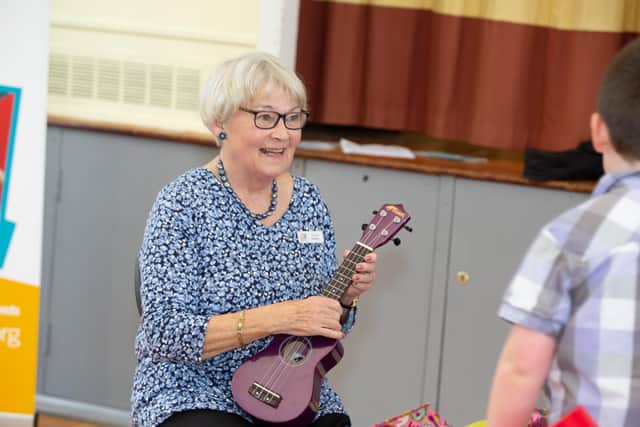SNAPS president Anne Gait shows off her guitar skills to youngsters. Picture: Templars Photography.