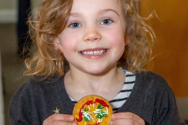 A young girl with a biscuit at the SNAPS president's tea party. Picture: Templars Photography.