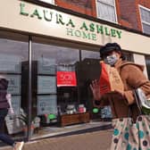 A woman wearing a face mask walking past a Laura Ashley store Picture: Yui Mok/PA Wire
