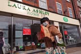 A woman wearing a face mask walking past a Laura Ashley store Picture: Yui Mok/PA Wire