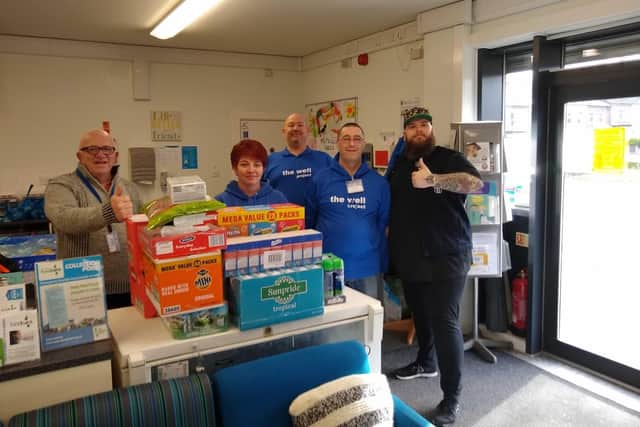 Jon Crowder making a donation to the Well Project in Normanton after raising more than 1,300 to support local food banks.