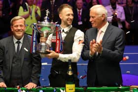 Judd Trump (centre) celebrates with the trophy after winning the 2019 Betfred World Championship alongside Barry Hearn (right).