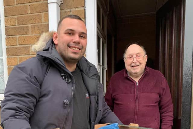 Kane delivering food packages to the city's elderly and most vulnerable