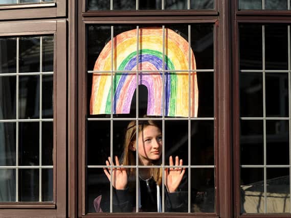 Fleur Hulme pictured with a rainbow in the window of her Leeds home.