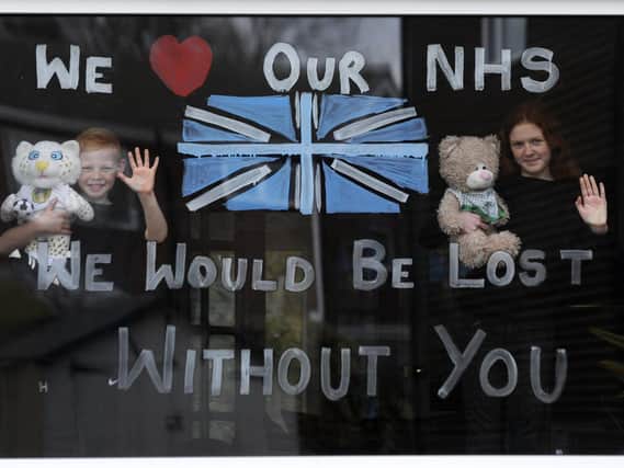Lydia Hardwick, 11, with her brother Daniel, 8, support the NHS by painting their window at their home in Leeds.