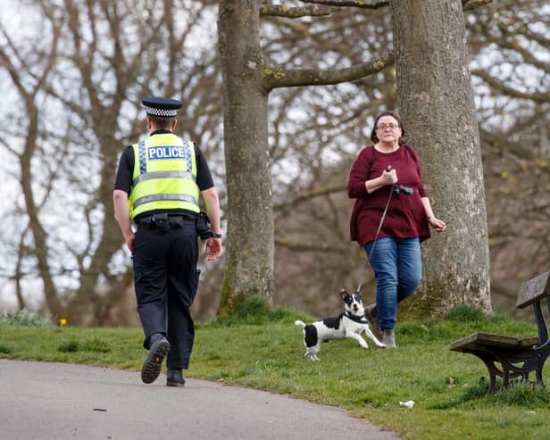 A policeman walks past a woman exercising with a dog in Roundhay Park, Leeds, as the UK continues in lockdown to help curb the spread of the coronavirus. Picture: Danny Lawson/PA