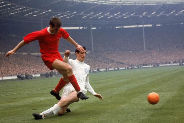 TOUGH: Norman Hunter, right, challenges Liverpool's Roger Hunt in one of his many battles in a Leeds United shirt. Picture by PA Photos/PA Wire.