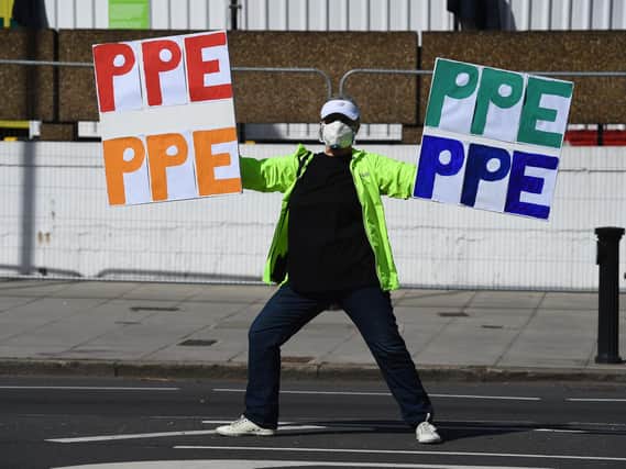 A demonstrator holds signs saying PPE outside St Thomas' Hospital in Central London where Prime Minister Boris Johnson is in intensive care as his coronavirus symptoms persist. Photo: PA