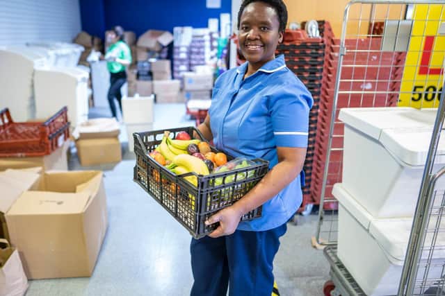 Lingile Maboyi, a nurse at St James Hospital, Leeds, receives the food package. Photo credit: Other