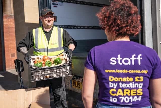 Helen Macdonald from Leeds Cares receives the food package from fresh produce supplier Delifresh. Photo credit: other