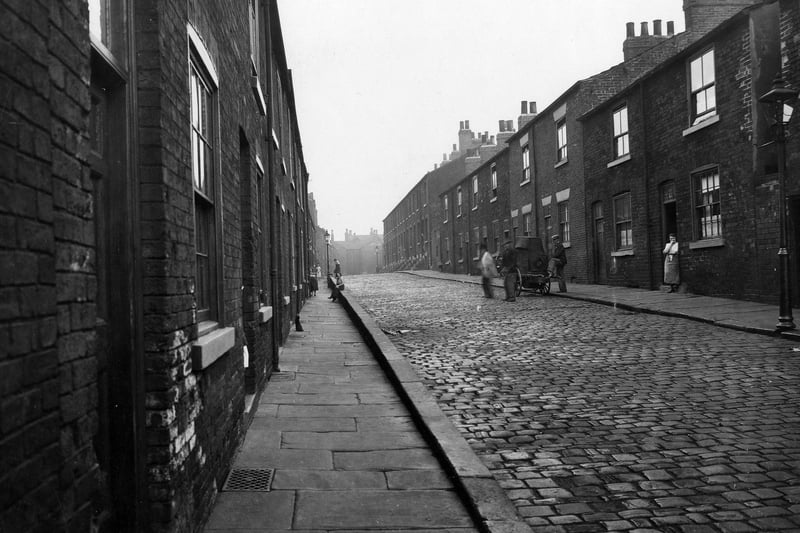 Apple Street looking north from the York Road end towards Great Garden Street. Terraced houses are on both sides of the road with a sunken footpath on the left. The street was demolished in the 1930s.