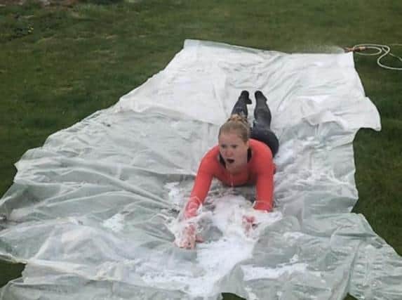Esme pictured doing on one of her challenges - 26 laps of a homemade slip and slide.