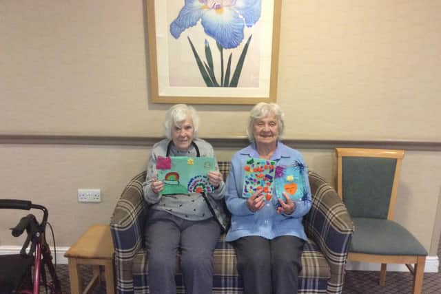 Cookridge Court Care Home residents Rose Jarman and Jean Harrison with artwork by local children.