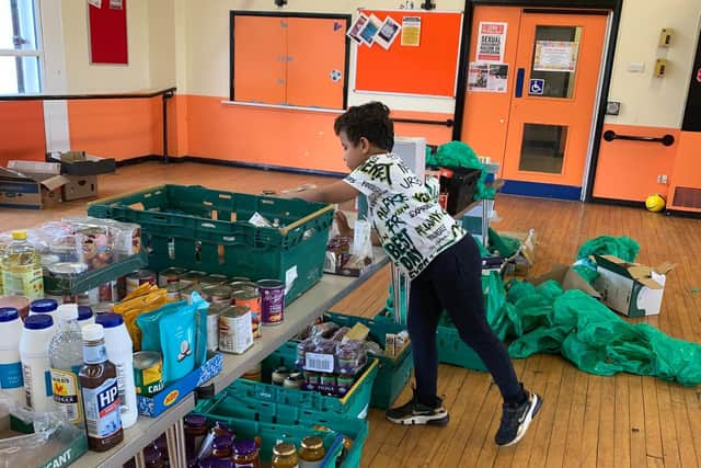 Zion Hutton-Simpson aged six, helping sort the stock at CYDC.