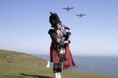 Pipe major Andy Reid of The Scots Guards plays his pipes on the cliffs of Dover, Kent, as two Spitfires from the Battle of Britain memorial flight fly overhead, ahead of commemorations to mark the 75th anniversary of VE Day.