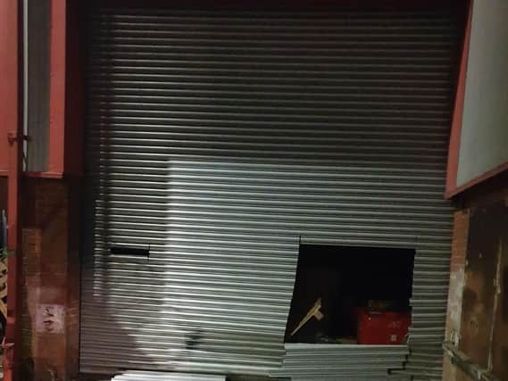 The hole made in the shutter by burglars of a warehouse in the Trafalgar Business Park in Salford, who stole 80,000 face masks destined for the NHS and care homes in West Yorkshire. PA photo.