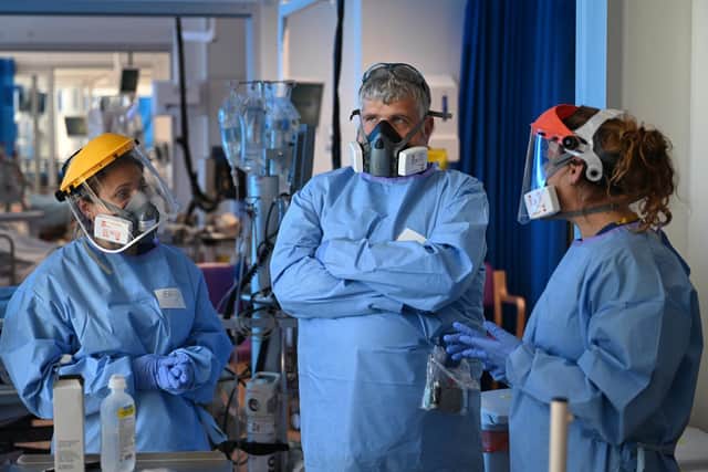 Clinical staff wear Personal Protective Equipment (PPE) as they care for a patient