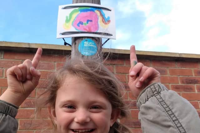 Katie Ward, five, with her picture of a girl with rainbow hair.