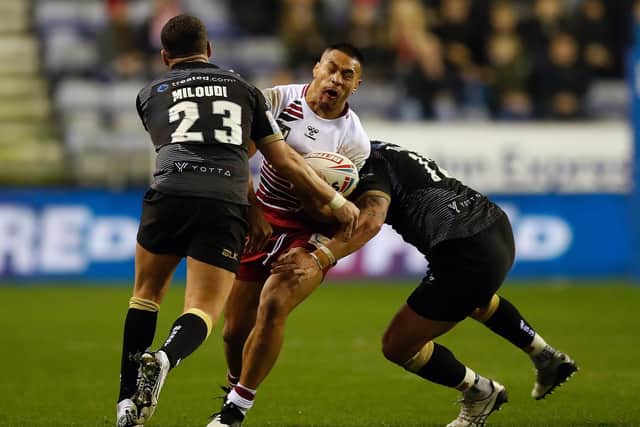 Wigan Warriors' Willie Isa is tackled by Toronto Wolfpack's Hakim Miloudi (left) and Toronto Wolfpack's Bodene Thompson (right), during the Betfred Super League match at DW Stadium, Wigan. PA Photo. Picture date: Thursday February 13, 2020. See PA story RUGBYL Wigan. Photo credit should read: Martin Rickett/PA Wire. RESTRICTIONS: Editorial use only. No commercial use. No false commercial association. No video emulation. No manipulation of images.