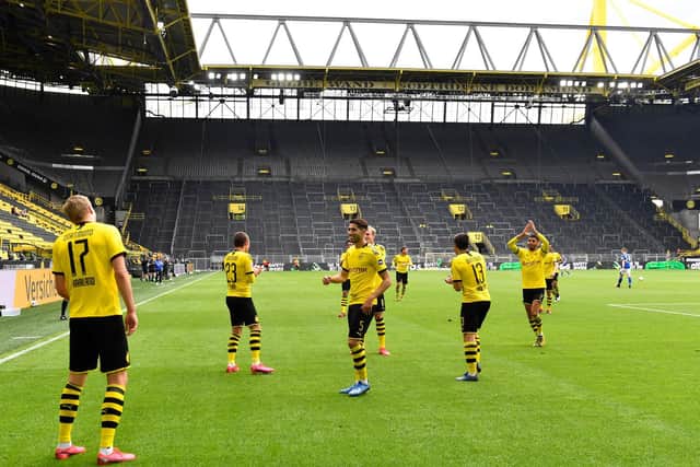 'ICONIC': Borussia Dortmund's Leeds-born striker Erling Haaland, left, celebrates his strike in last weekend's 4-0 win against Schalke 04 social distancing style in a stadium without fans.  Photo by Martin Meissner/Pool via Getty Images.