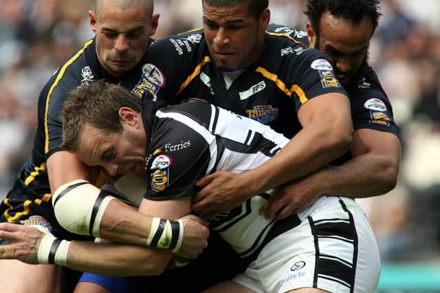 Ewan Dowes, playing for Hull, is tackled by Rhinos' Ian Kirke, Ryan Bailey and Jamie Jones-Buchanan. Picture by Andrew Varley.