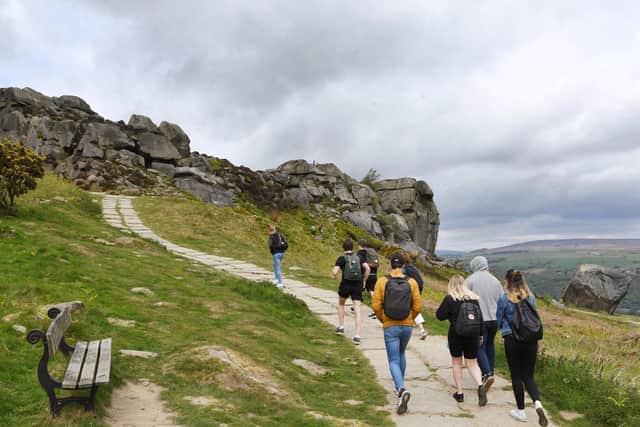 People in England will be able to gather outdoors in socially-distanced groups of six from Monday. Pictured people enjoying a walk on the Cow and Calf in Ilkley.