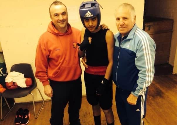 Fighting fit: Khalid Ayub flanked by his trainers is set to step up from the amateur ranks to the professional boxing game.