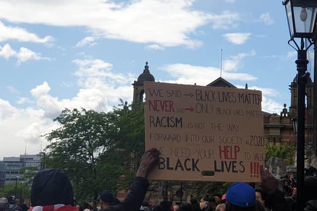 Demonstrators hold up a sign outside Leeds Town Hall (photo: Rosie W).