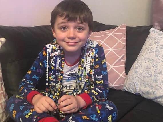 Thomas, six, with his incredible collection of beads of courage
