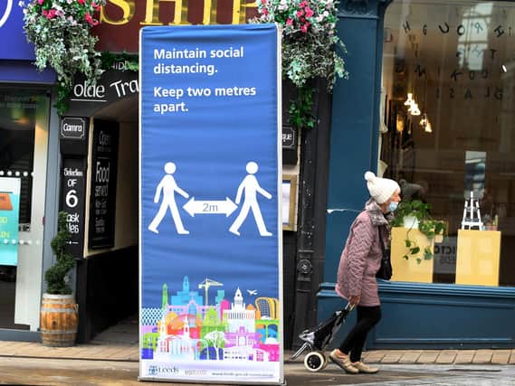 Social distancing measures are just some of the precautions retailers are taking as a shopper ventures out on Briggate, Leeds.