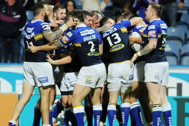 Jubilant teammates engulf Ryan Hall as Leeds snatch the league leaders' shield from Wigan's grasp. Picture by Steve Riding.