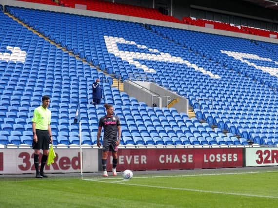 NEW NORMAL - Kalvin Phillips takes a corner for Leeds United in front of an almost entirely empty stand at the Cardiff City Stadium. Pic: PA